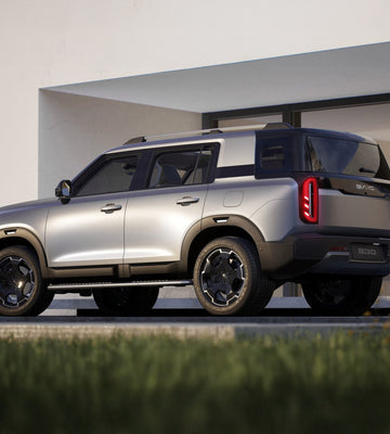 Silver SUV parked in front of a modern building with a clear sky.