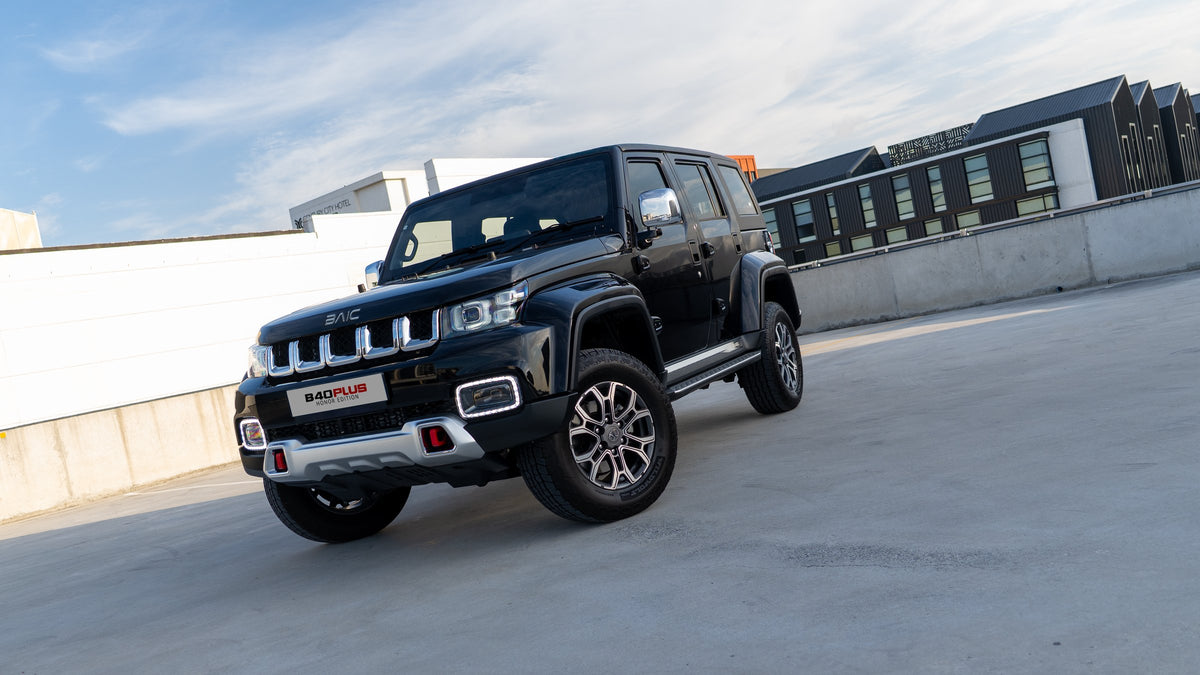 BAIC B40 Plus in black, front three-quarter, showing the five-slot grille, round LED headlamps and all-terrain tyres